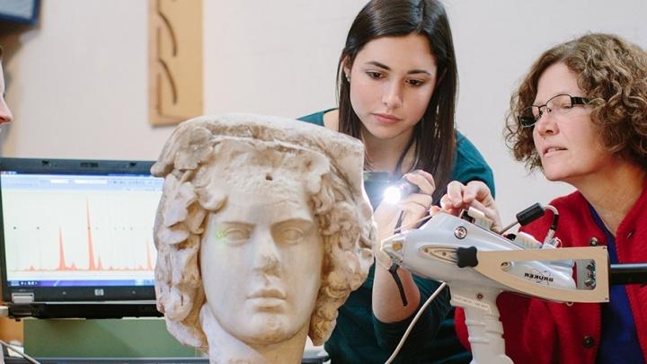 Trinity professor and her student examine an ancient sculpted bust.