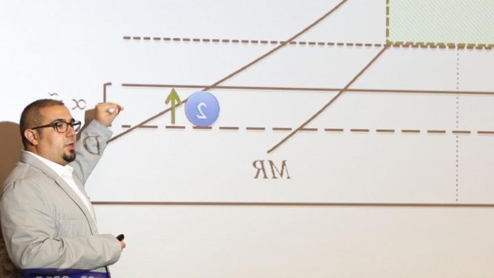 Professor uses the projector to show math students a graph