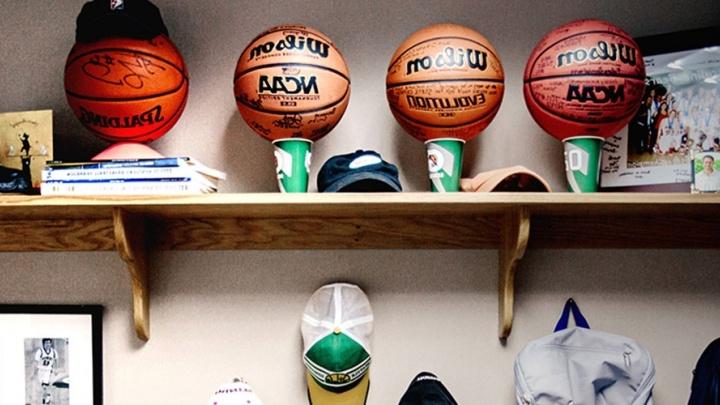 Signed sports memorabilia is displayed on a shelf.