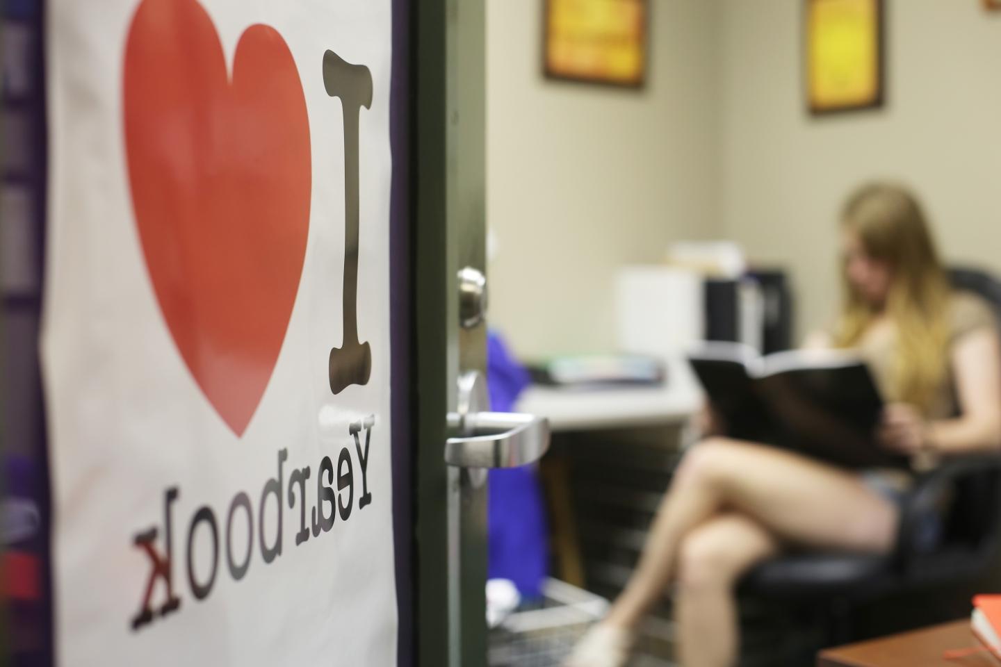 a sign on an open office door reads "I Heart Yearbook"