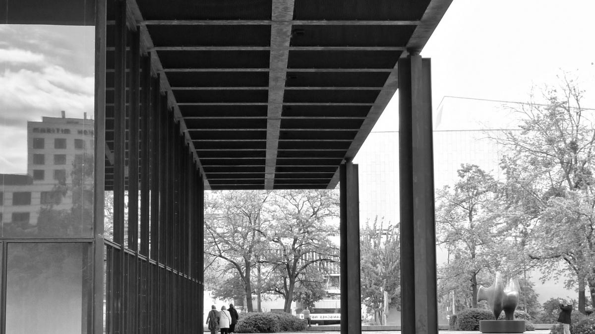 A person walks through a covered space on a mid-century building